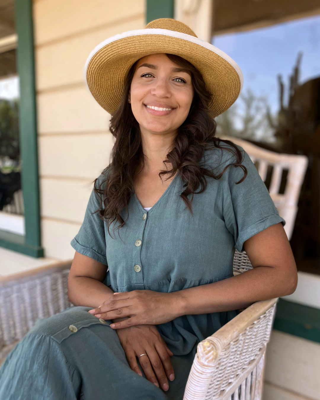 Katherine Wandell sitting in a wicker chair on a porch